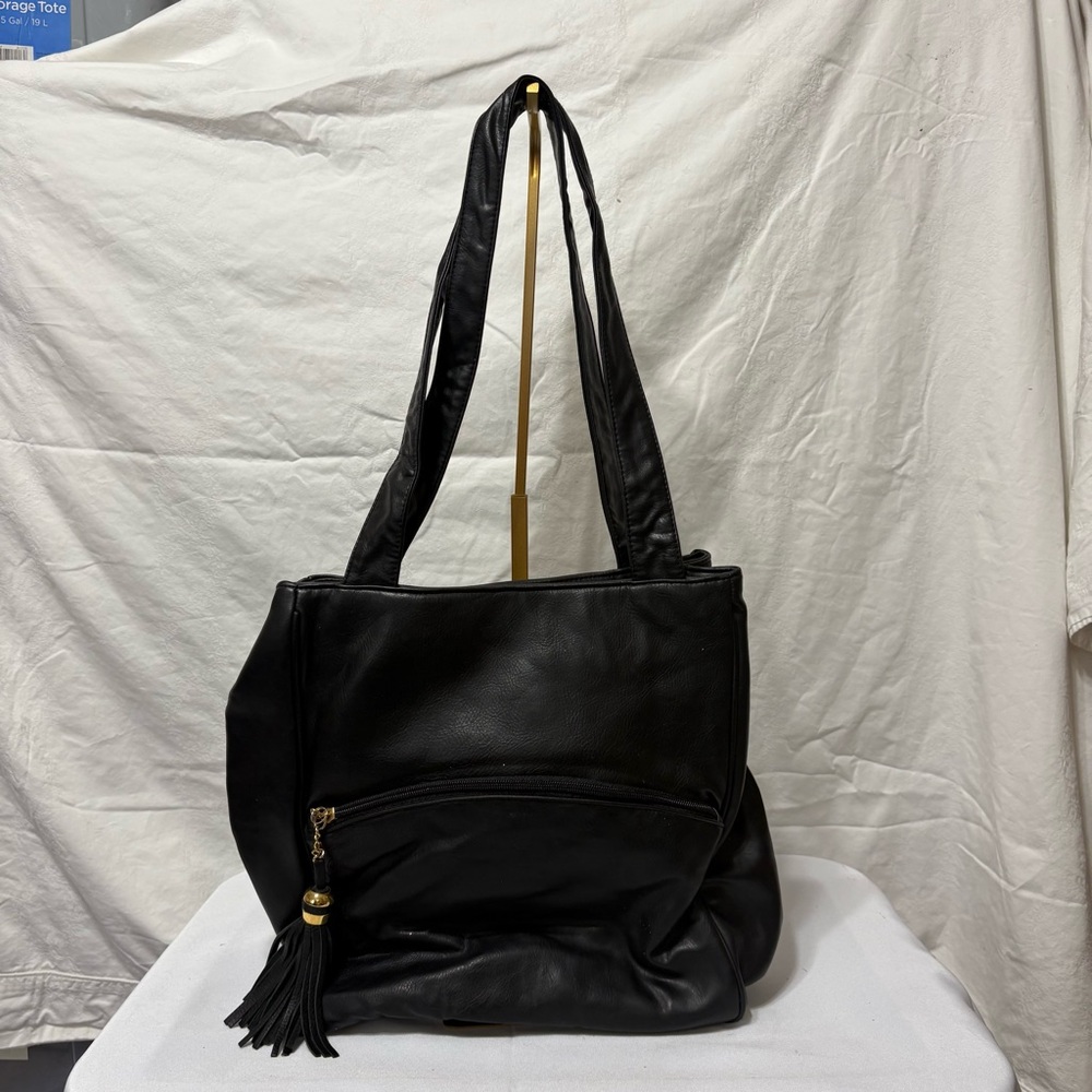 Black tote bag with a tassel accent.